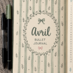 Un bullet journal ouvert avec des pages colorées pour le mois d'avril