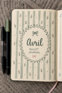 Un bullet journal ouvert avec des pages colorées pour le mois d'avril
