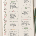 Un Bullet Journal ouvert avec des citations inspirantes écrites en calligraphie colorée.